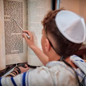 יהדות, דת, בר מצווה בבית כנסת, עלייה לתורה, תפילין, קריאה בתורה, בית כנסת, טלית, ספר תורה, אירוע דתי, התרגשות, מסורת יהודית, טקס בר מצווה, חתן בר מצווה, ארון הקודש, ברכות, משפחה, תפילה, זריקת סוכריות, חגיגה, שמחה