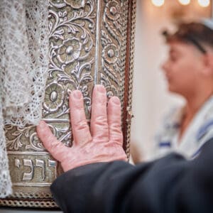 יהדות, דת, בר מצווה בבית כנסת, עלייה לתורה, תפילין, קריאה בתורה, בית כנסת, טלית, ספר תורה, אירוע דתי, התרגשות, מסורת יהודית, טקס בר מצווה, חתן בר מצווה, ארון הקודש, ברכות, משפחה, תפילה, זריקת סוכריות, חגיגה, שמחה