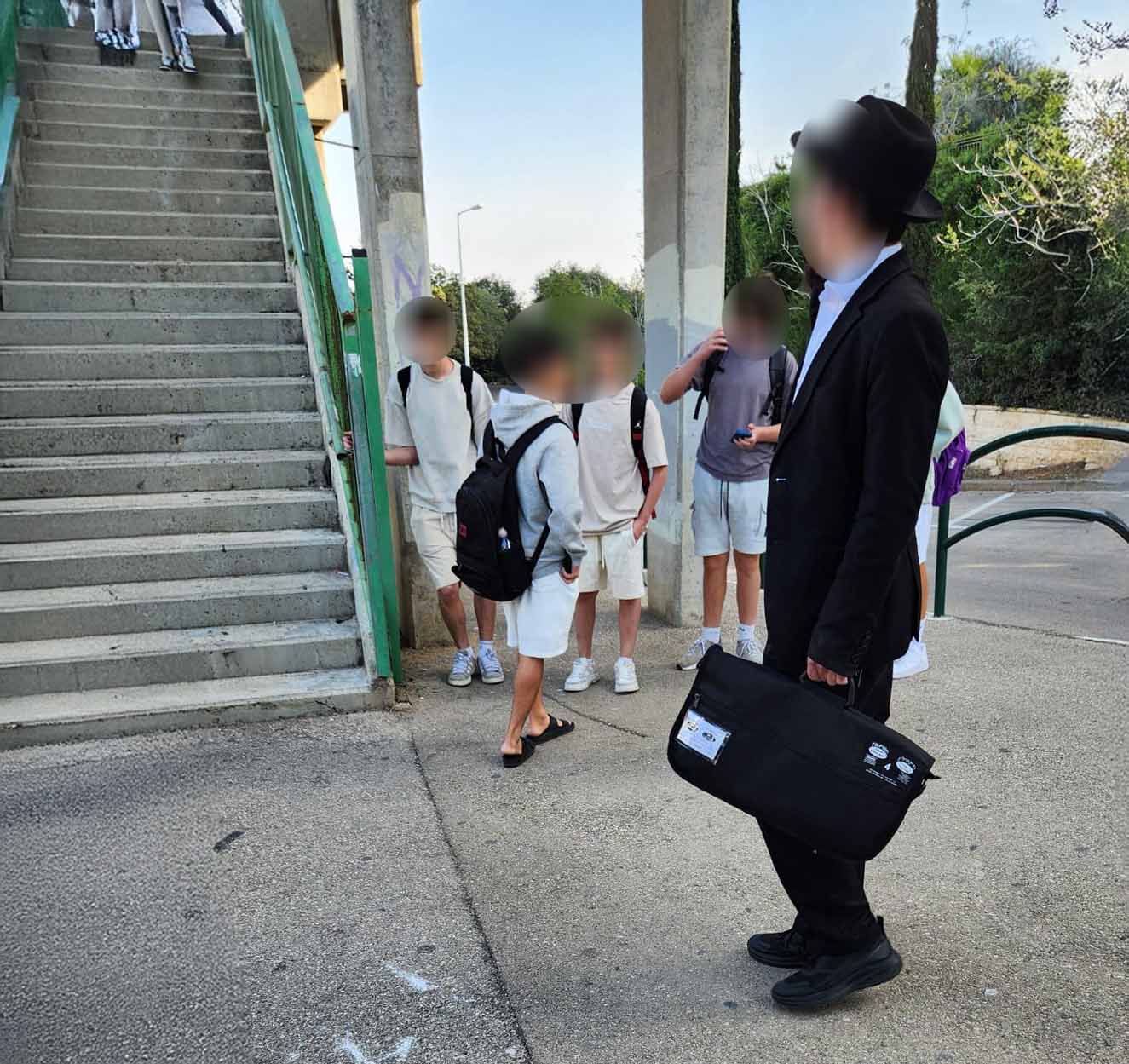 צעיר חרדי פונה לתלמידים ליד בית הספר אליאנס (צילום: קוראי חי פה בשטח)