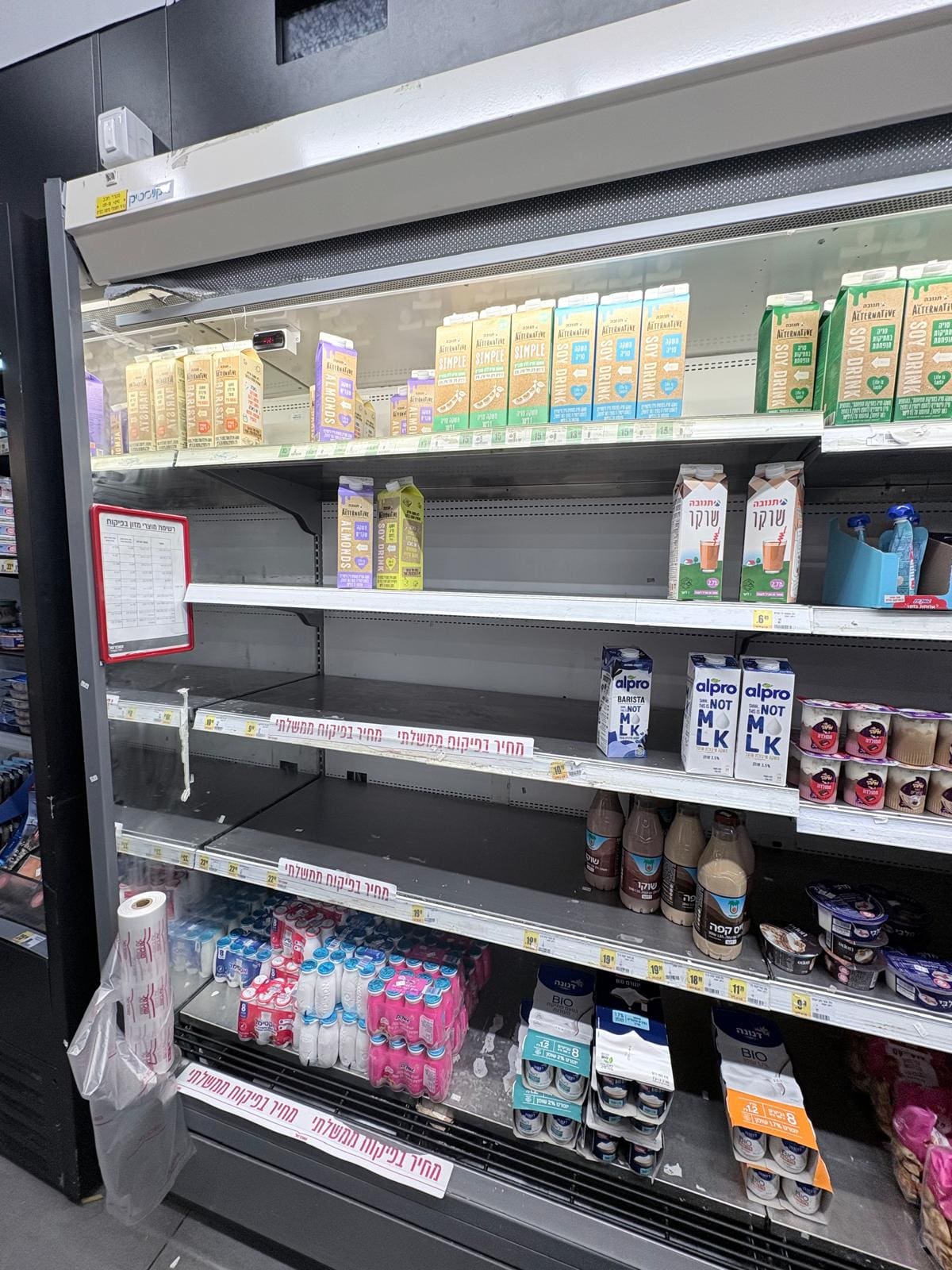 מדפי החלב הריקים בסופר בסביוני דניה (צילום: מיכל גרובר)