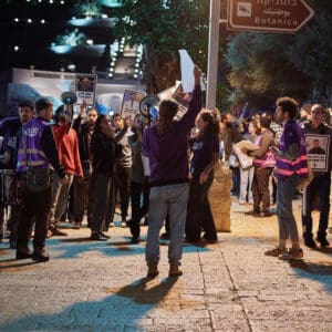 יום השיבוש, מחאה ארצית, שביתה אזרחית, מחאה חברתית, אלימות בחברה הערבית, הפגנה, חיפה, כיכר אונסק"ו, המושבה הגרמנית, משתתפים בהפגנה, שלטי זיכרון, קורבנות אלימות, מודעות ציבורית, מאבק חברתי, סולידריות, קהילה, נשים מפגינות, התכנסות ציבורית, צילום דוקומנטרי, צילום רחוב, אירוע לילה, תאורת רחוב, סרט סגול, אבל ציבורי, כאב, זכויות אזרח, ביטחון אישי, ישראל, קהל, תקשורת חזותית