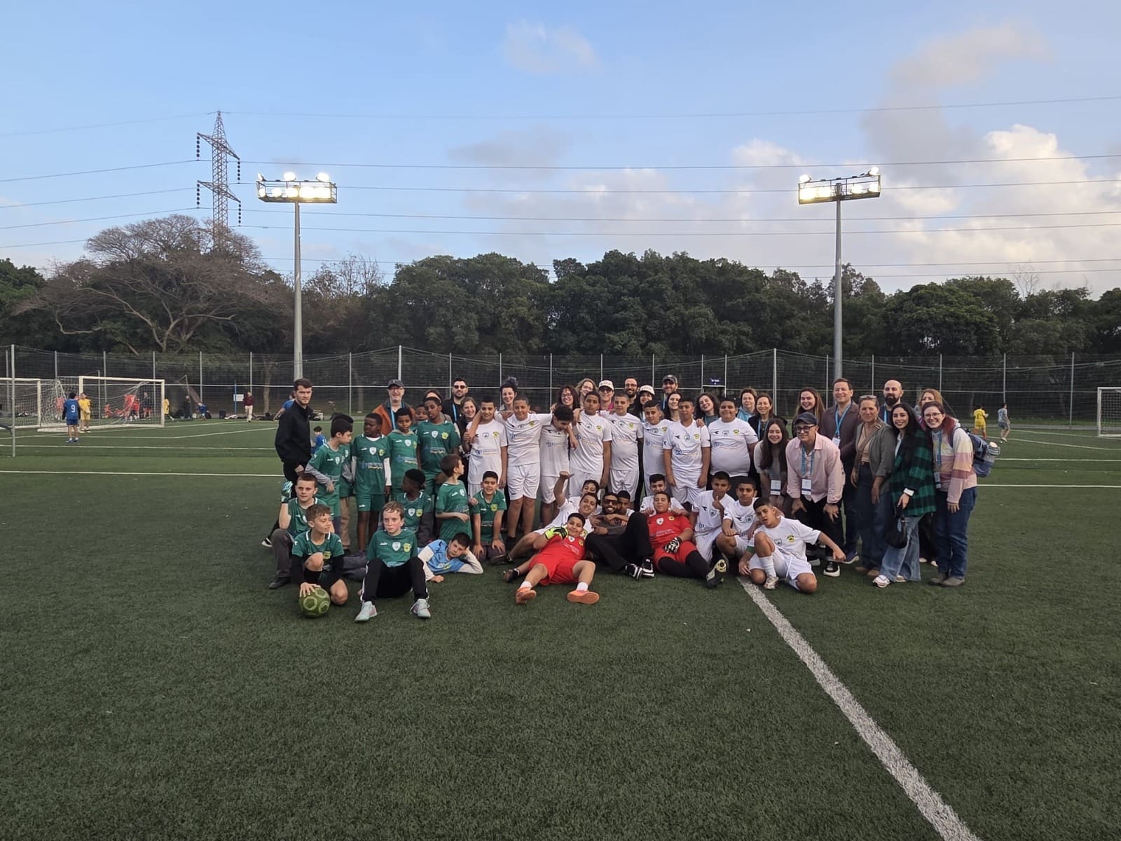חברי משלחת המחנכים מבוסטון עם שחקני הכדורגל הצעירים במשחק הגמר (צילום: שותפות חיפה בוסטון).