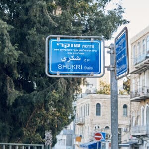 מדרגות עירוניות, חיפה, שכונת הדר, רחוב מדורג, ירידה במדרגות, מרחב ציבורי, סביבה עירונית, מדרגות אבן, מעקה מתכת ירוק, הליכה משותפת, צילום רחוב, זוג מאחור, שביל רגלי, בנייני מגורים ישנים, צמחייה עירונית, שכונה ותיקה, אינטימיות יומיומית, תיעוד עירוני, חיים בעיר,  מדרגות שוקרי חיפה, שכונת הדר, מדרגות עירוניות, רחוב מדורג, שביל רגלי, מדרגות אבן, מעקה מתכת ירוק, חיבור בין רחובות, טופוגרפיה הררית, מרחב ציבורי, מעבר הולכי רגל, בנייני מגורים ותיקים, צמחייה עירונית, סמטאות חיפה, צילום רחוב, תיעוד עירוני, נוף שכונתי, תנועה יומיומית, אדריכלות מקומית, מדרון