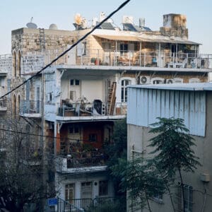 ואדי, סאליב, מבנים עתיקים, בתי אבן, אדריכלות עותמאנית, אדריכלות ערבית מסורתית, קשתות אבן, חלונות מקושתים, תריסי עץ, מרפסות ברזל מעוטרות, בנייה מאבן גיר, מבנה לשימור, שכונה היסטורית, מרקם עירוני ותיק, חזיתות אבן, בניין פינתי, רחוב הררי, טופוגרפיה תלולה, מורשת אדריכלית, מבנים לשימור, צילום אדריכלות