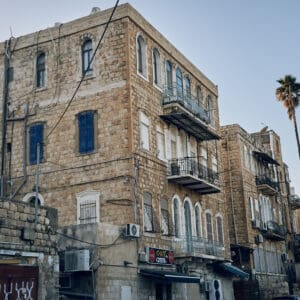 ואדי, סאליב, מבנים עתיקים, בתי אבן, אדריכלות עותמאנית, אדריכלות ערבית מסורתית, קשתות אבן, חלונות מקושתים, תריסי עץ, מרפסות ברזל מעוטרות, בנייה מאבן גיר, מבנה לשימור, שכונה היסטורית, מרקם עירוני ותיק, חזיתות אבן, בניין פינתי, רחוב הררי, טופוגרפיה תלולה, מורשת אדריכלית, מבנים לשימור, צילום אדריכלות