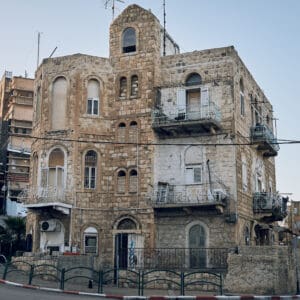 ואדי, סאליב, מבנים עתיקים, בתי אבן, אדריכלות עותמאנית, אדריכלות ערבית מסורתית, קשתות אבן, חלונות מקושתים, תריסי עץ, מרפסות ברזל מעוטרות, בנייה מאבן גיר, מבנה לשימור, שכונה היסטורית, מרקם עירוני ותיק, חזיתות אבן, בניין פינתי, רחוב הררי, טופוגרפיה תלולה, מורשת אדריכלית, מבנים לשימור, צילום אדריכלות