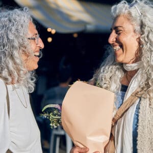 תאומות, אחיות, תאומים, חברים בשוק, שוק תלפיות חיפה, מפגש חברתי, חיוך ושמחה, שיחה בין חברים, דיוקן רחוב, צילום רחוב, קניות בשוק, זר פרחים, חוויית שוק, קהילה מקומית, אווירה אורבנית, אנשים מבוגרים, שיער אפור מתולתל, אינטראקציה אנושית, רגע אותנטי, תרבות מקומית, רחוב עירוני, תאורה טבעית, תיעוד חברתישיער טבעי, שיער אפור טבעי, שיער לבן טבעי, שיער מתולתל טבעי, תלתלים כסופים, ללא צבע שיער, ללא החלקה, מראה טבעי, יופי טבעי, הזדקנות טבעית, קבלה עצמית, סגנון אישי, אותנטיות, מרקם שיער טבעי, דיוקן רחוב, צילום טבעי