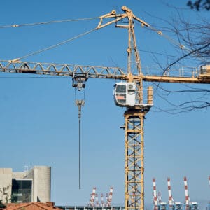 מנוף צריח, עגורן צריח, אתר בנייה, בנייה לגובה, פיתוח נדל״ן, שלד בטון, זרוע מנוף, משקולת איזון, תא מפעיל, ציוד הרמה, תשתיות בנייה, פרויקט מגורים, קו רקיע עירוני, עבודות בנייה, תכנון הנדסי, בטיחות באתר, בנייה עירונית, צילום תעשייתי