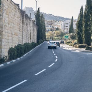 שכונת הדר, ציר תלול, רחוב היסטורי, בנייני אבן ישנים, מבנים לשימור, מבנים נטושים, אדריכלות עותמאנית, מרפסות ברזל, חלונות מקושתים, קירות מתקלפים, גרפיטי, תשתיות חשופות, מדרכות צרות, קיר תומך מאבן, טופוגרפיה הררית, חיבור בין העיר התחתית להדר, נוף מפרץ חיפה