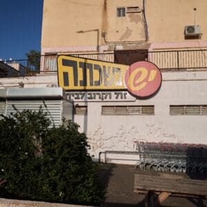יש בשכונה, סופרמרקט, רשת שיווק, מכולת, קמעונאות, שלט צהוב, עגלות קנייה, מבנה ישן, שולחן פיקניק, צילום רחוב, מוצרי צריכה, קניות, מסחר, מחירים