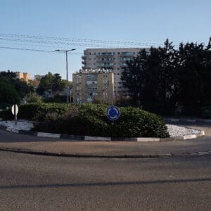 פינוי בינוי, התחדשות עירונית, תמ״א 38, הריסה ובנייה מחדש, חיזוק מבנים, שדרוג תשתיות, בנייה רוויה, צפיפות עירונית, תכנון עירוני, מדיניות דיור, התחדשות שכונות ותיקות, פיתוח עירוני, שינוי ייעוד קרקע, הגדלת זכויות בנייה, שימור מול פיתוח, חידוש חזיתות, שיפור איכות חיים, השקעות נדל״ן, עליית ערך נכסים, פרויקטים למגורים, שיתוף דיירים, פיצוי דיירים, יזמות נדל״ן, רגולציה תכנונית, היתרי בנייה, ועדות תכנון ובנייה, שיקום מבנים ישנים, התחדשות תשתיות עירוניות, התחדשות מרכזי ערים, בנייה לגובה, בניין מגורים ישן, שיכון, בלוק דירות, חזית בניין, ארכיטקטורה ישראלית, שכונת מגורים, עיר ישראלית, רחוב עירוני, תחנת אוטובוס, תחבורה ציבורית, תחנת המתנה, עץ אורן, צמחייה עירונית, מדרכה, אבני סלע, כביש רטוב, שמש חזקה, שמיים כחולים, אור וצל, חזית מוזנחת, תריסים סגורים, מזגנים חיצוניים, אנטנות על הגג, צילום רחוב, סביבה עירונית, דיור ציבורי, מבנה בטון, שכונה ותיקה, נוף עירוני