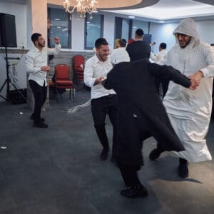 הילולת פורים, חג פורים, ישיבה, חגיגה דתית, שמחת תורה, קהילה יהודית, חיפה, אירוע דתי, מסורת יהודית, תלמידי ישיבה, קריאת מגילה, תחפושות, סעודת מצווה, אחדות, חוסן אזרחי, שגרה בצל מלחמה, חיים בצל מלחמה, רוח יהודית, תרבות יהודית, חגיגות למרות המלחמה, אמונה, התכנסות קהילתית, חיי דת בישראל