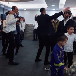 הילולת פורים, חג פורים, ישיבה, חגיגה דתית, שמחת תורה, קהילה יהודית, חיפה, אירוע דתי, מסורת יהודית, תלמידי ישיבה, קריאת מגילה, תחפושות, סעודת מצווה, אחדות, חוסן אזרחי, שגרה בצל מלחמה, חיים בצל מלחמה, רוח יהודית, תרבות יהודית, חגיגות למרות המלחמה, אמונה, התכנסות קהילתית, חיי דת בישראל