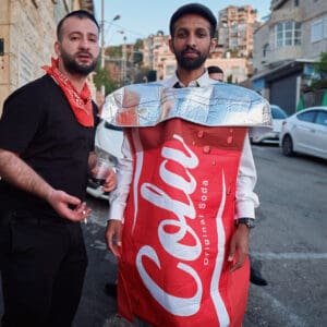 תחפושת, הילולת פורים, חג פורים, ישיבה, חגיגה דתית, שמחת תורה, קהילה יהודית, חיפה, אירוע דתי, מסורת יהודית, תלמידי ישיבה, קריאת מגילה, תחפושות, סעודת מצווה, אחדות, חוסן אזרחי, שגרה בצל מלחמה, חיים בצל מלחמה, רוח יהודית, תרבות יהודית, חגיגות למרות המלחמה, אמונה, התכנסות קהילתית, חיי דת בישראל