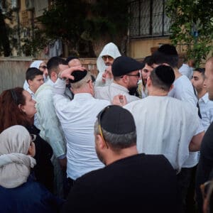 הילולת פורים, חג פורים, ישיבה, חגיגה דתית, שמחת תורה, קהילה יהודית, חיפה, אירוע דתי, מסורת יהודית, תלמידי ישיבה, קריאת מגילה, תחפושות, סעודת מצווה, אחדות, חוסן אזרחי, שגרה בצל מלחמה, חיים בצל מלחמה, רוח יהודית, תרבות יהודית, חגיגות למרות המלחמה, אמונה, התכנסות קהילתית, חיי דת בישראל