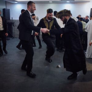 הילולת פורים, חג פורים, ישיבה, חגיגה דתית, שמחת תורה, קהילה יהודית, חיפה, אירוע דתי, מסורת יהודית, תלמידי ישיבה, קריאת מגילה, תחפושות, סעודת מצווה, אחדות, חוסן אזרחי, שגרה בצל מלחמה, חיים בצל מלחמה, רוח יהודית, תרבות יהודית, חגיגות למרות המלחמה, אמונה, התכנסות קהילתית, חיי דת בישראל