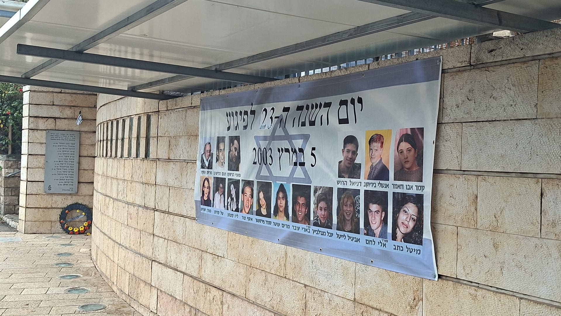 שלט עם תמונות הנרצחים בפיגוע במקום הפיגוע (צילום: אלבום פרטי)