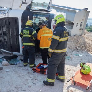 חילוץ, נהג, משאית, התהפכות, תאונה, הצלה, חירום, פינוי, פצוע, כוחות, כבאים, אמבולנס, רפואה, בטיחות, סכנה, דרכים, תעבורה, כבאות, מד״א, רכב כבד