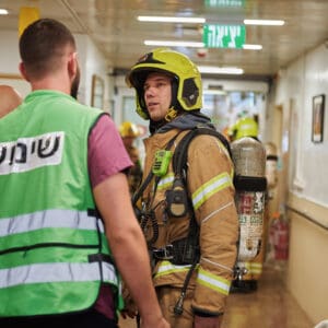 כבאי, כבאית, כבאות, כיבוי אש, שריפה, להבות, עשן, ציוד מגן, קסדה, מדים, צינור מים, מים, חום, סכנה, חירום, פעולה, הצלה, משאבת מים, זירה, פיח, צוות כיבוי, רכב כיבוי, חילוץ, חילוץ מגובה, חילוץ מרכב, חילוץ ממים, ציוד חילוץ, נשיאת פצועים, סנפלינג, מערכות נשימה, חדירה מבוקרת, חילוץ מיוחד, כבאות והצלה, מפגע, אשכול אש, חומרים מסוכנים, פריצה, סולם אש, זרנוק, הידרנט, מערכת גילוי אש, מערכת כיבוי אוטומטית, מניעת דליקות, בטיחות אש, חקירת שריפות, שיקום נזקי שריפה, מתנדב, תרגיל כיבוי, כוננות, אירוע רב נפגעים, אחראי בטיחות, הדרכה, רישוי עסקים, תקנות כיבוי אש, חדר בקרה, קצף כיבוי, שמיכת כיבוי, מטף כיבוי, עזרה ראשונה, פינוי, נקודת כינוס, קריסת מבנים, אש, כבאית, סולם, צוות, אורות, צופר, קורבן, פצוע, ריח, סירנה, בית חולים, רמב״ם, מרכז רפואי, הכרמל, בני ציון