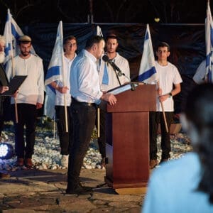 יום זכרון, עצרת, טירת כרמל, דודו כהן, ראש עיר, זיכרון, טקס, ערב, נרות, קהל, הורים, שכולים, אבל, דגל, חללים, חיילים, הנצחה, שידור, הקלטה, במה, נאום, התכנסות, כבוד, שתיקה, דומייה, דגלים