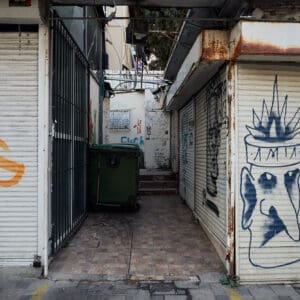 מסחר, חנויות, רחוב הרצל, הדר הכרמל, חזית עסק, תריסי גלילה, שלטים, חנות בגדים, חנות תכשיטים, מכונות תפירה, מדרכה, ריצוף אבן, בובות תצוגה, חלון ראווה, גרפיטי, אמנות רחוב, סמטה, פח אשפה ירוק, צמחייה עירונית, שיחים, עמודי תאורה, תמרורים, סימטה, פשע, הזנחה, גרפיטי, אכיפה,  זנות, סמים