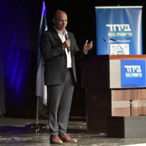 נאום, כנס, בחירות, פוליטיקה, פוליטיקאי, נואם, במה, מרצה, חליפה, מיקרופון, פודיום, דוכן, שלט, דגל, תאורה, עמידה, דיבור, מחווה, גבר, עיתונות, תיעוד, אירוע, ישראל, קמפיין, נפתלי בנט, ביחד בראשות בנט, קריית חיים
