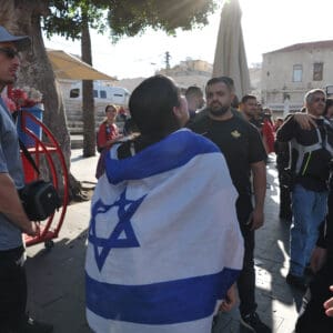 הפגנה, מחאה, שלטים, דגלים, דגל ישראל, נאום, נואם, במה, מיקרופון, קהל, אנשים, רחוב, מבנים, עצים, כיכר, צעדת מחאה, כרזות, פוליטיקה, אקטיביזם, התקהלות, פלסטין, פלסטינים, כיבוש, 1967, עימות