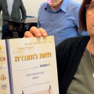 איידה אסולין עם התעודה לאחר שכתבה בספר לזכרו של בנה החלל בני אסולין הי״ד (צילום: ירון כרמי – חי פה-TV)
