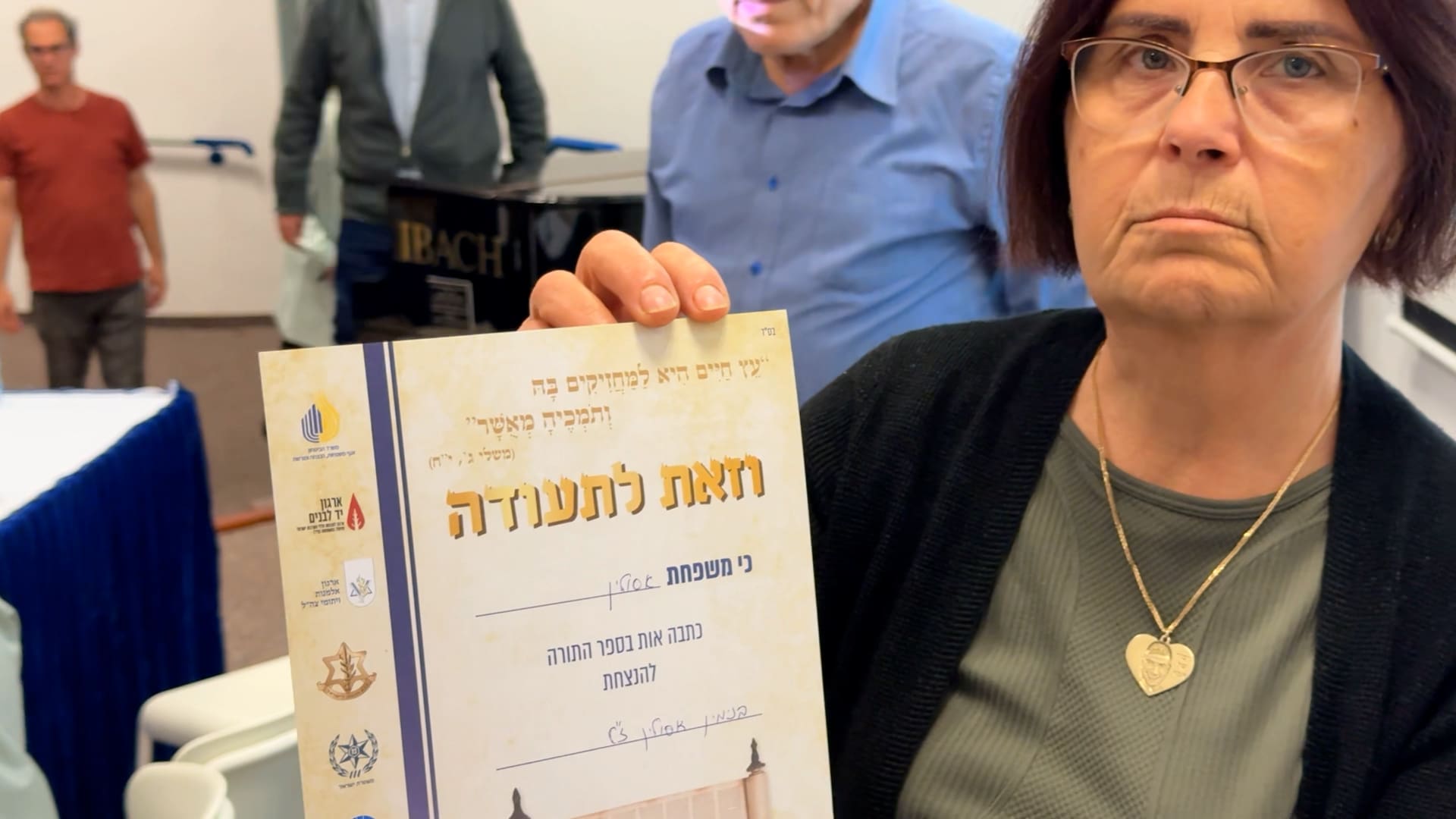 איידה אסולין עם התעודה לאחר שכתבה בספר לזכרו של בנה החלל בני אסולין הי״ד (צילום: ירון כרמי - חי פה-TV)