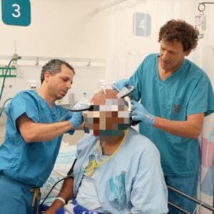 ד"ר אלון סיני, נוירופיזיולוג במחלקה לנוירוכירורגיה ברמב"ם (מימין) וד"ר ליאור לב-טוב, יחד עם ח', המטופל הישראלי הראשון (צילום: רמב״ם)
