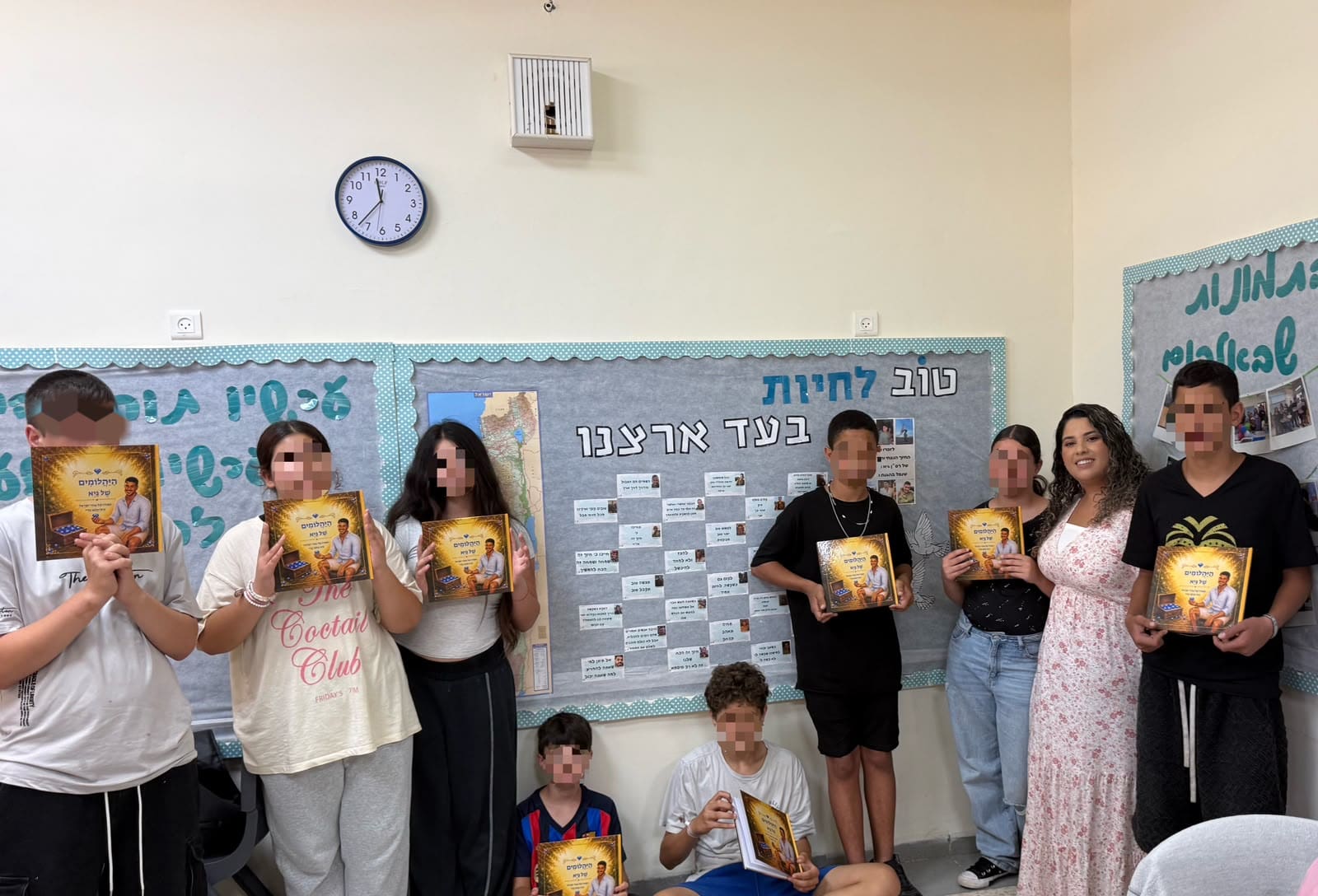 מנהלת בית הספר נטלי חי, המחנכת טליה בן סבו ותלמידי “כיתת אלה” עם הספר “היהלומים של גיא” (צילום: “אור הים - רננים”)