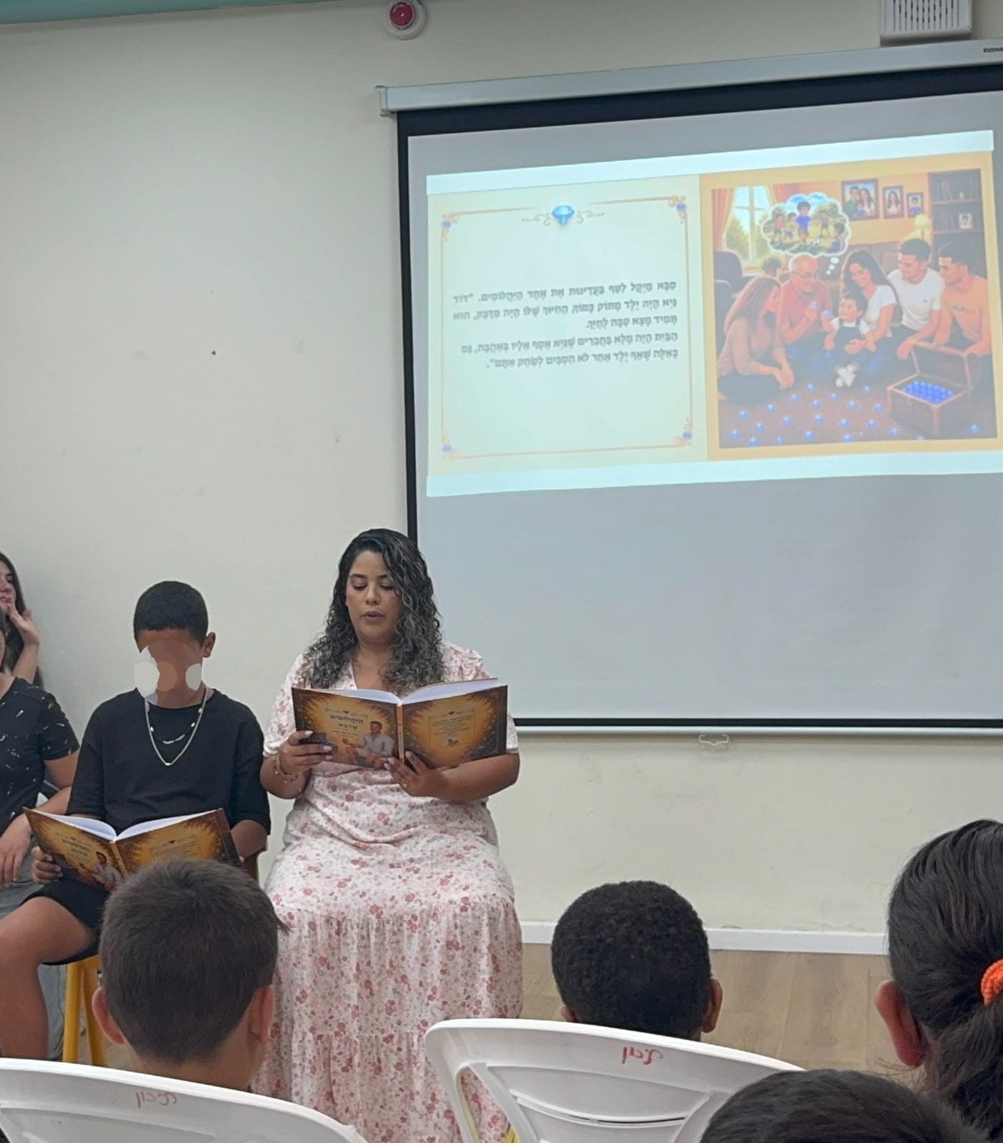 מנהלת בית הספר נטלי חי, המחנכת טליה בן סבו ותלמידי “כיתת אלה” עם הספר “היהלומים של גיא” (צילום: “אור הים - רננים”)