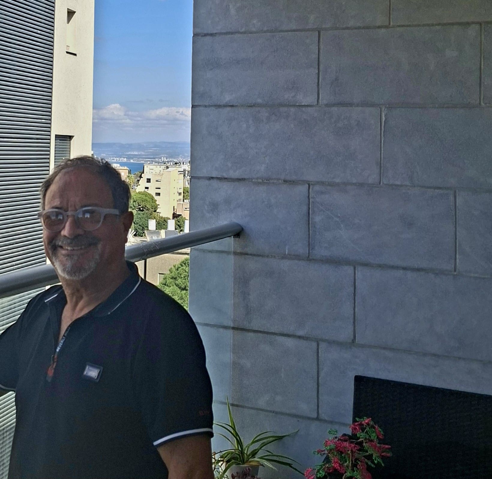 יוסקה רובין - במבטו מהמרפסת אל עבר מפרץ חיפה (צילום: רחלי אורבך)